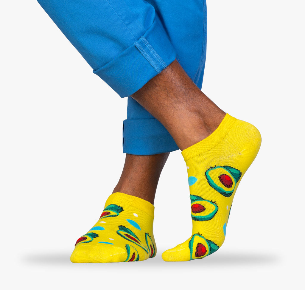 Grüne Avocados auf gelben Sneaker Sockne