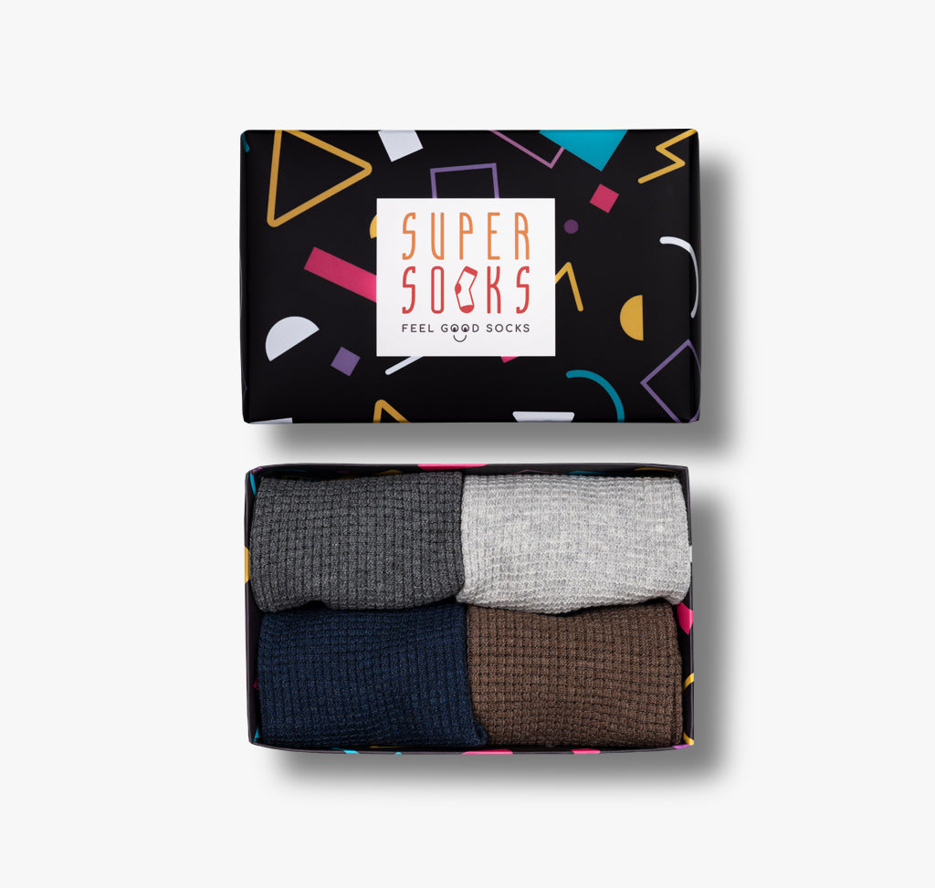 Bunte Socken in vier Farben grau hellgrau blau und braun in einer Geschenkbox