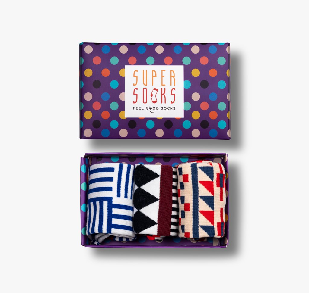 Gepunktete Geschenkschachtel mit drei Paar gemusterten bunten Socken