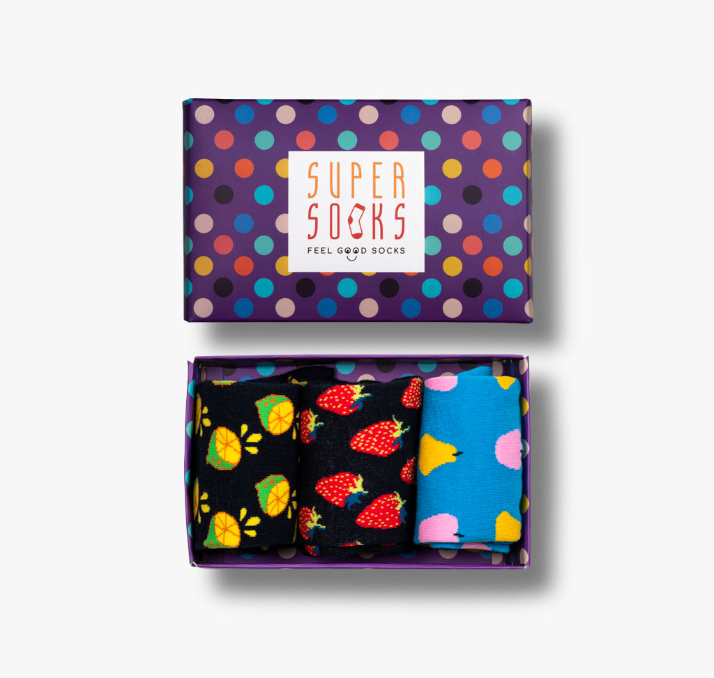 Geschenkbox mit bunten Punkten und drei Paar lustigen Socken mit Zitronen Erdbeeren und Apfel Birne