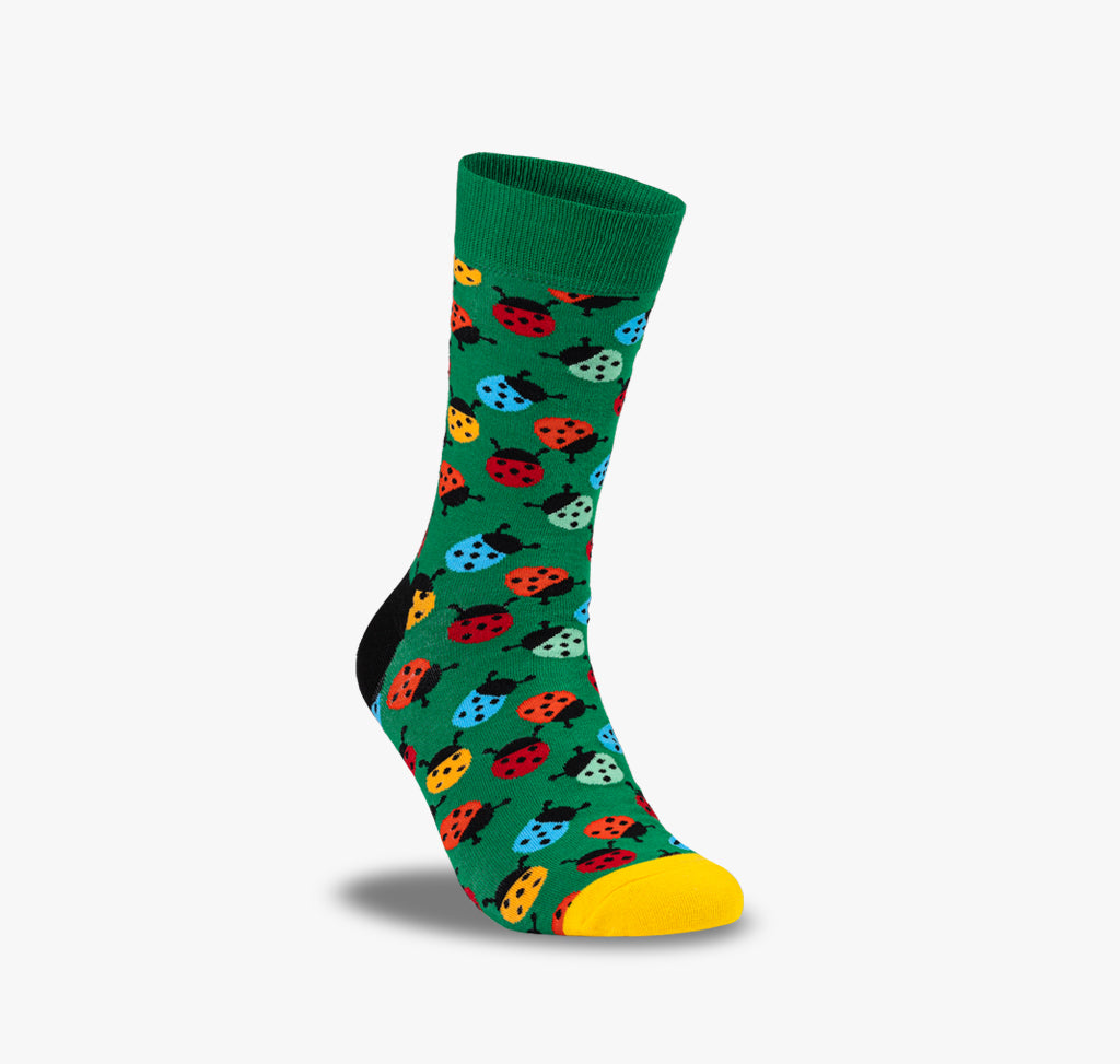 Bunte Marienkäfer Socken für Herren und Damen auf grünem Hintergrund