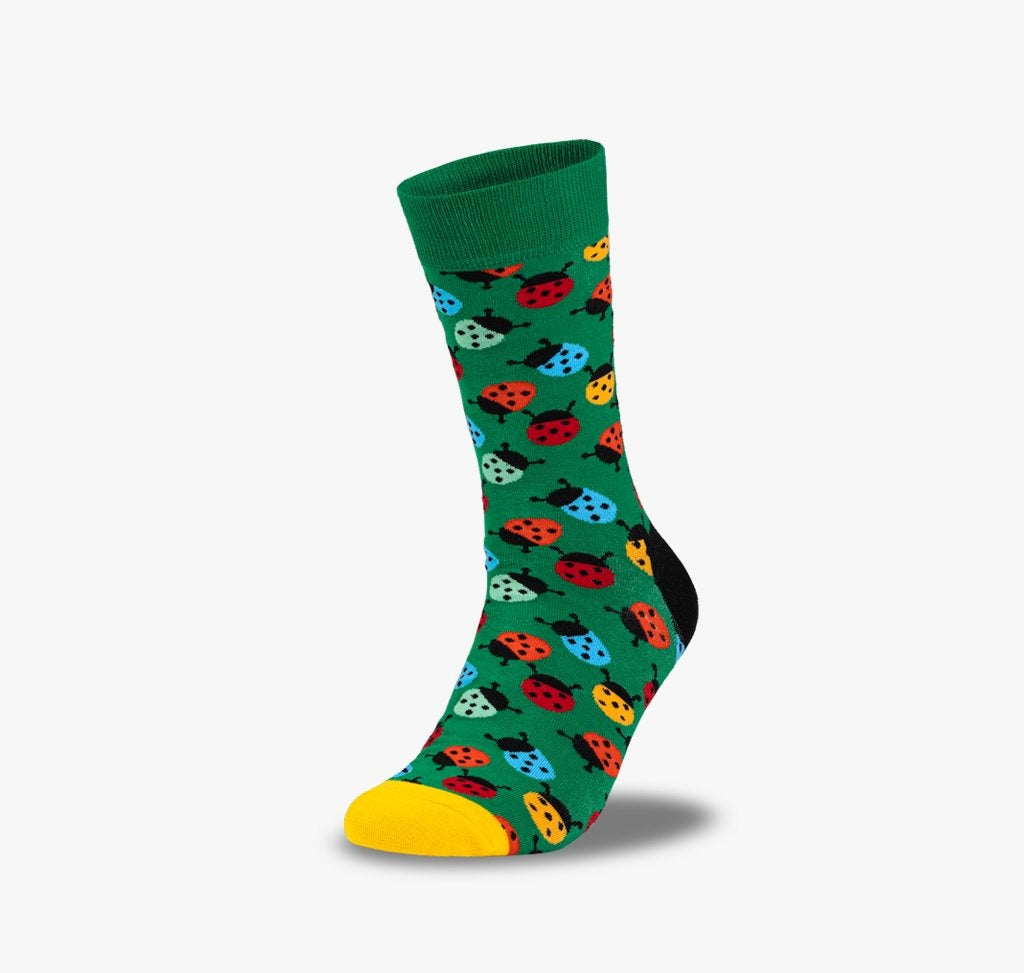 Bunte Marienkäfer Socken für Herren und Damen auf grünem Hintergrund