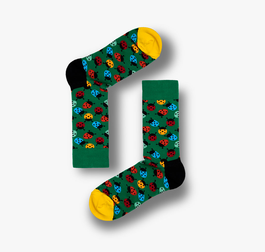 Socken mit Marienkäfer auf grünem Hintergrund für Herren und Damen